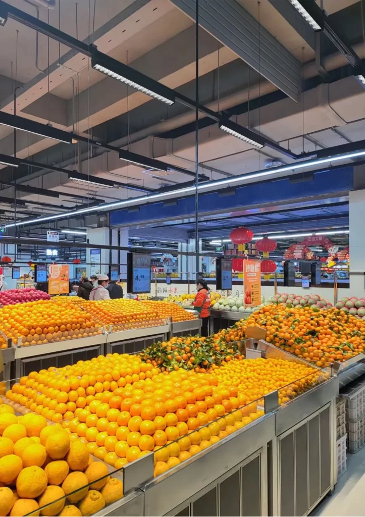 shelf display lighting in supermarket fruit section using linear track lighting for fresh produce display